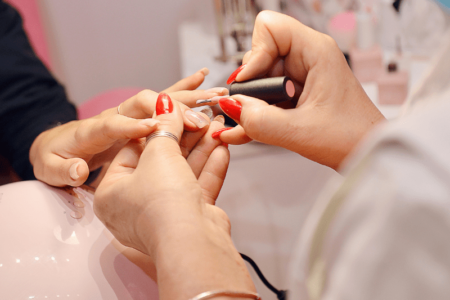 Manicure pintando as unhas da sua cliente